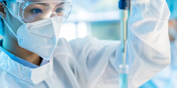 Scientist working with a pipette in a lab.