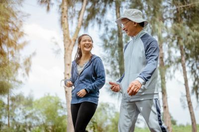 Two people jogging outdoors, smiling and enjoying the activity.