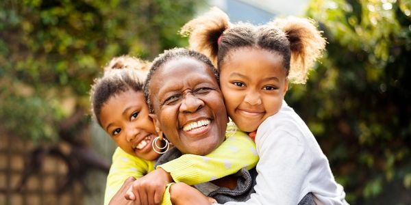 Happy  grandma receiving warm hugs from children 