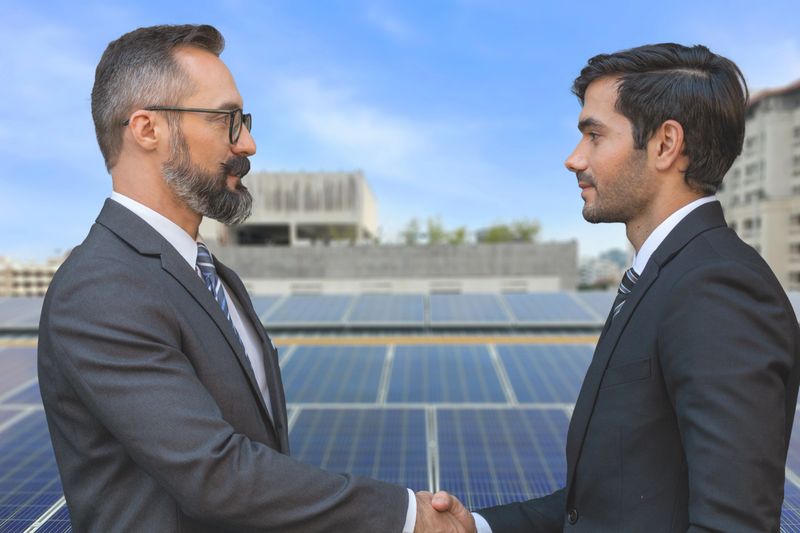 Business men and engineer are discussing or checking new project for solar energy on roof top. Clean energy for business development to avoid pollution