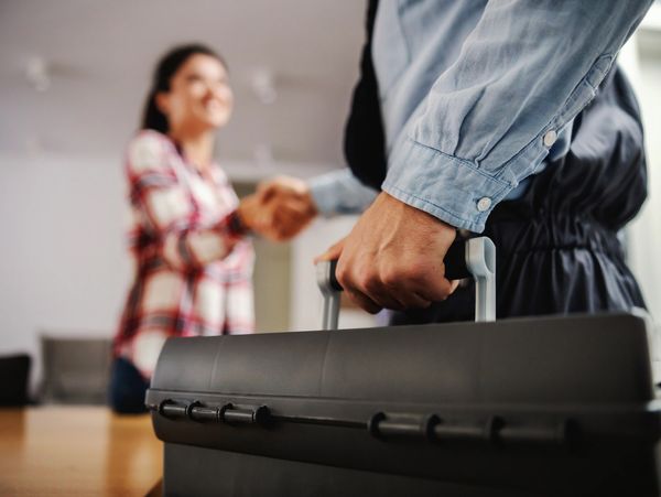 Two people shaking hands, one holding a toolbox.