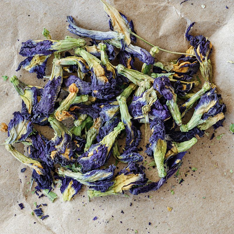 selective focus topview of anchan flower herbal blue tea Clitoria Ternatea, on a sheet of kraft paper