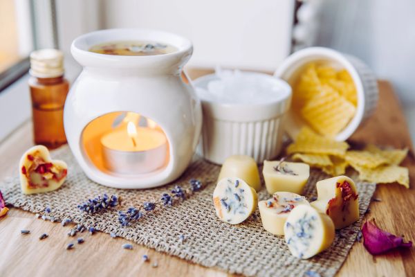 Aromatherapy candle setup with wax melts and dried lavender.