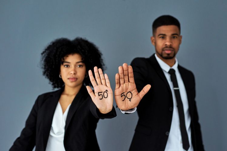 Man and woman showing equality symbols on their palms.