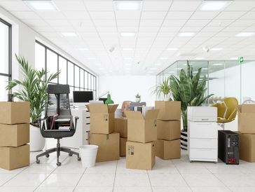 Office space filled with cardboard boxes and furniture.