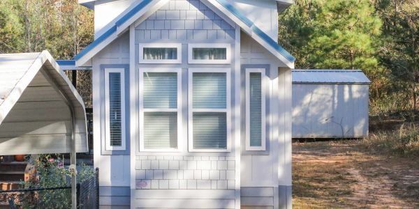 Front view of a small white house with blue trim.