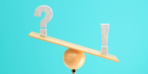 A balance seesaw with a question mark and exclamation mark.