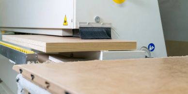 Wood panel being processed by an industrial woodworking machine.