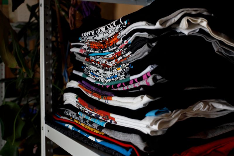 selective focus photo of t-shirts with bright prints, printed by silkscreen. serigraphy production. printing images on t-shirts in a design studio.