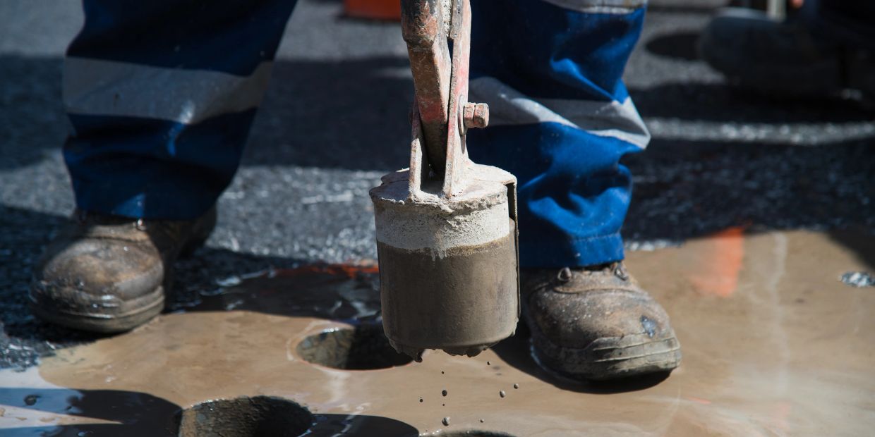 Worker removing a concrete core after drilling a clean opening