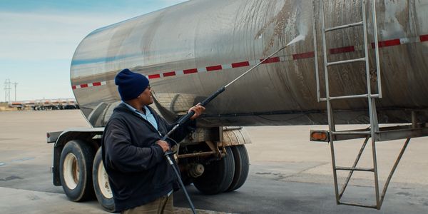 Man pressure washing a tanker truck.