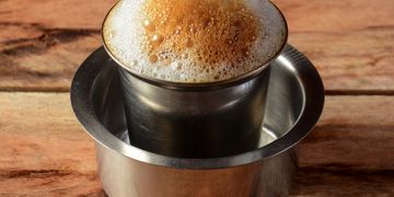 Traditional South Indian filter coffee served in a stainless steel tumbler and dabara.