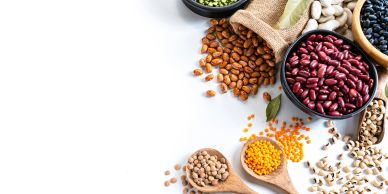 Assorted Canadian pulses, including lentils, chickpeas, peas and beans, arranged in bowls and wooden spoons.