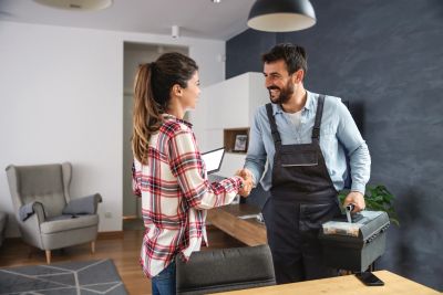 Man and woman shaking hands indoors.