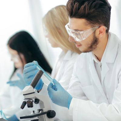 Scientists in lab coats working with test tubes.