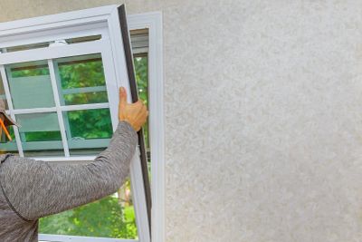 Person installing a window screen.
