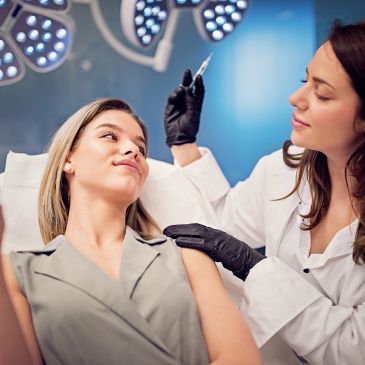Woman receiving an injection from a healthcare professional.