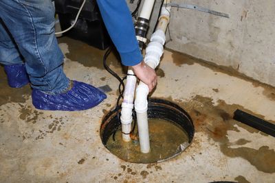 A plumbing technician servicing a sump pump.