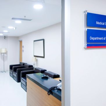 Clean hospital waiting area with reception desk and seating.