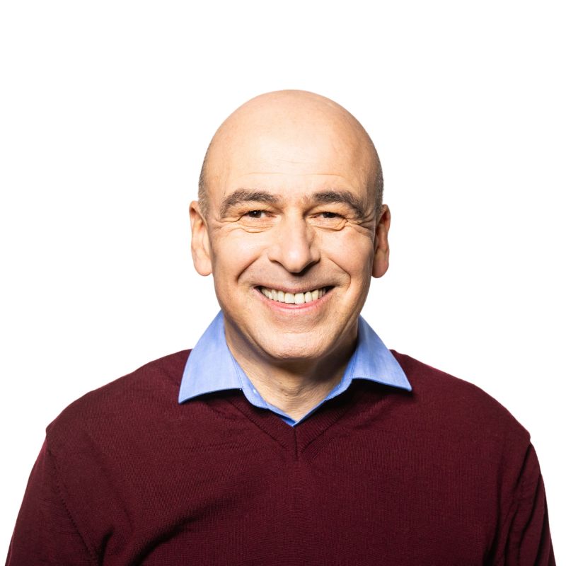 Happy mature man standing against white background. Caucasian man with shaved head looking at camera and smiling.