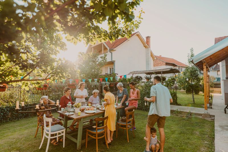 Photo of multi generation family, having party in the backyard. It's a post covid gathering, out in the open to protect an elderly members of the family.