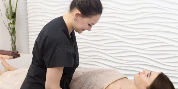 A therapist giving a massage to a woman.