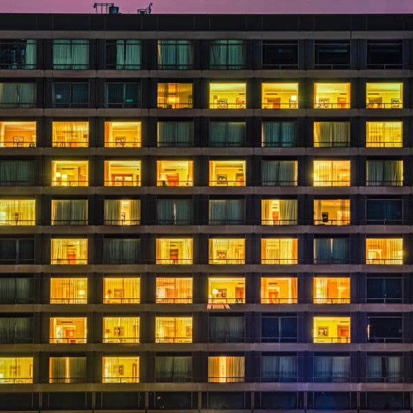 Lit apartment windows in a building at dusk.