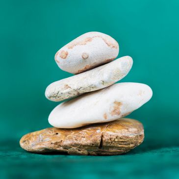 balanced stack of smooth stones - symbolizing grounding, balance, and mindful healing