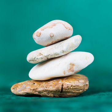 Stacked stones balanced on a turquoise surface.
