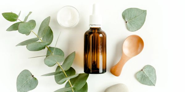 Natural skincare items with eucalyptus leaves on white background.