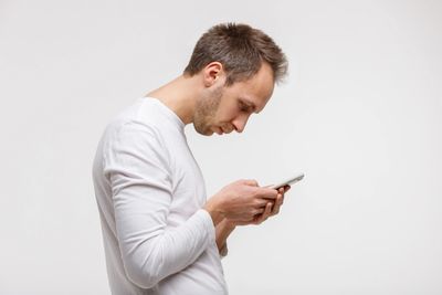 Man with bad posture uses cell phone and suffers from tech neck