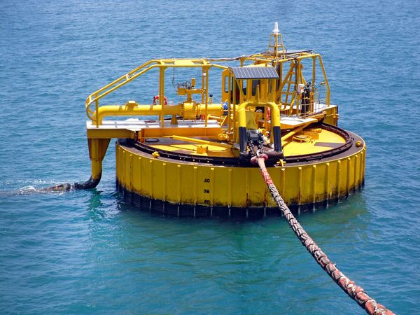 Yellow offshore buoy floating on calm blue ocean water.