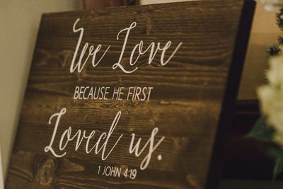Wooden plaque with a biblical quote about love.