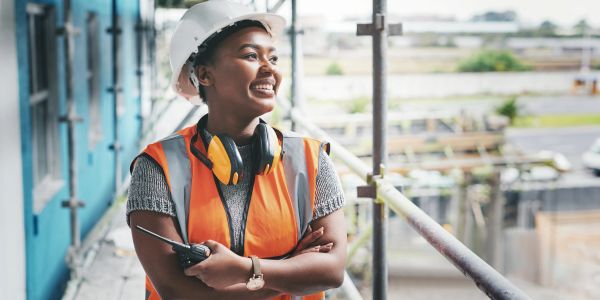Smiling construction worker wearing a hard hat and safety vest.
