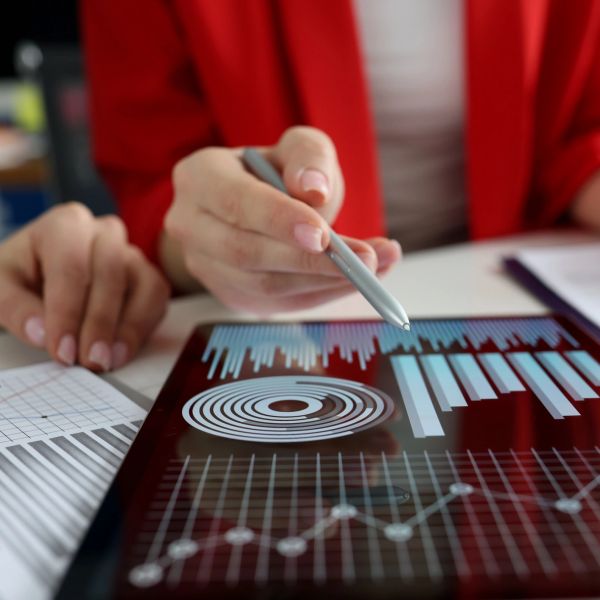 Person analyzing data charts on a tablet with a stylus pen.