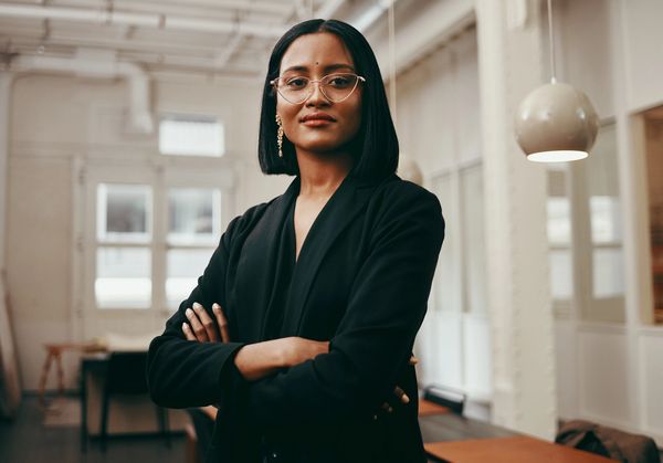 Confident woman with crossed arms in office.