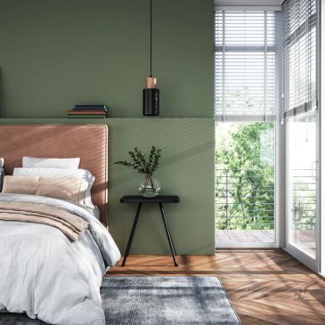 Cozy bedroom with green walls and natural light.