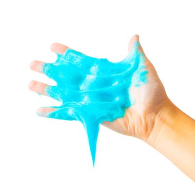 Hand holding and stretching bright blue slime against white background.