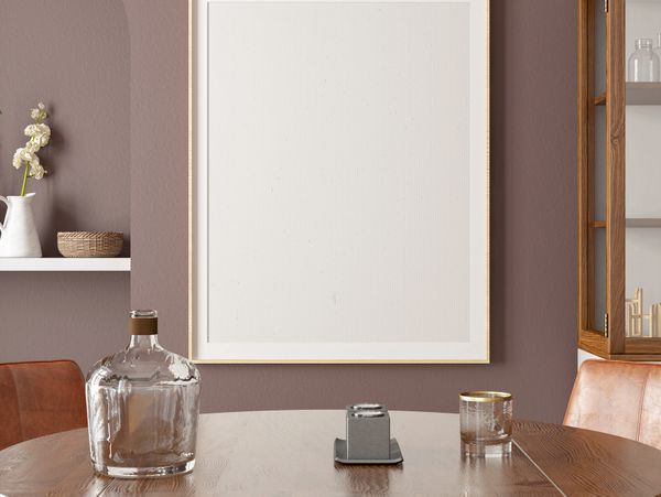 Minimalist dining table setup with glassware and blank framed art.