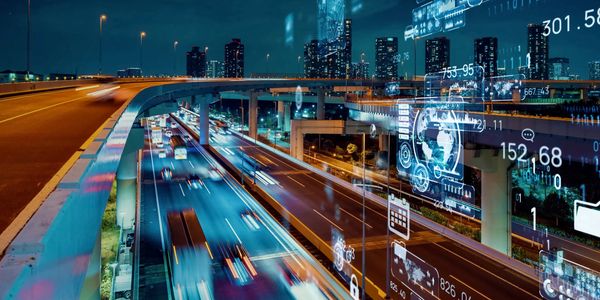 Nighttime city highway with futuristic digital data overlays.