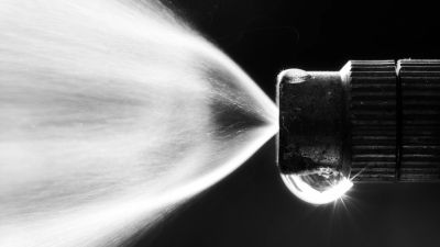 Close-up of a spray nozzle releasing mist.