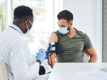 Doctor measures patient's blood pressure during a medical checkup.
