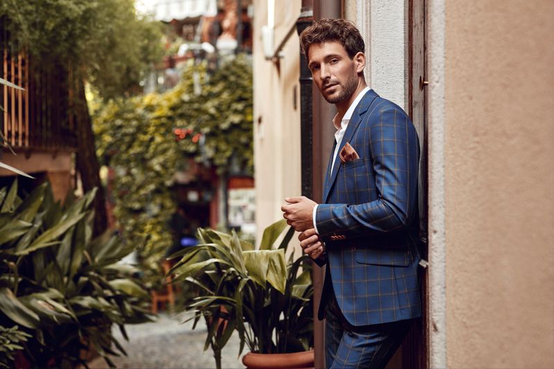 Young handsome man in classic suit with checked pattern