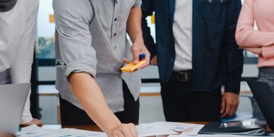 Person pointing and discussing documents in a meeting.