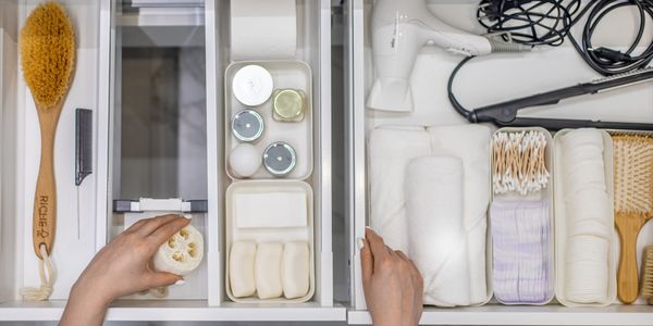 Organized drawer with toiletries, towels, and hair tools.