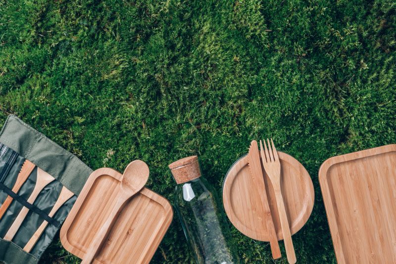 Fabric bags, glass jars, metal straws, bamboo cutlery on green grass, moss background. Eco friendly and reuse concept. Top view. Sustainable lifestyle. Zero waste, plastic free concept. Picnic.