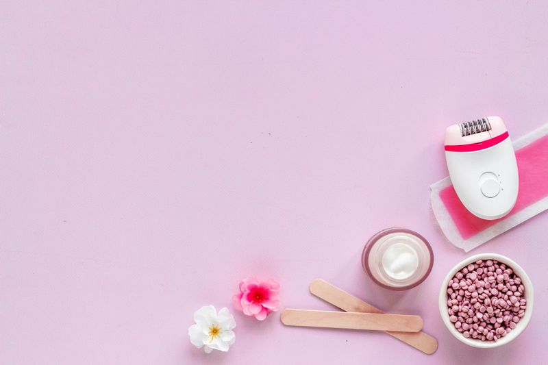 Set of epilation means - epilator with wax strips, razor and flowers.