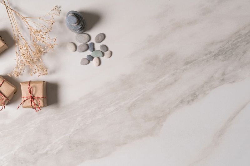 white zen balance stones and gift box on marble table, top view.