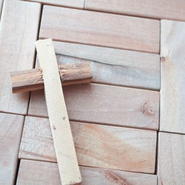 Two wooden sticks forming a cross on wooden blocks.