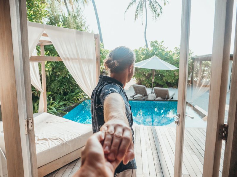 Pov of couple holding hands, man leading girlfriend to luxury villa in the Maldives